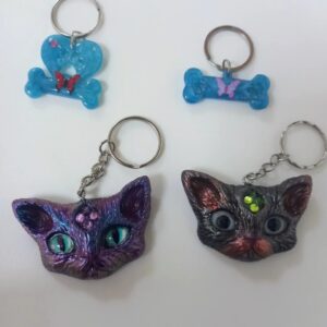 Llaveros artesanales de resina con gatos, huesitos y mariposas