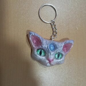 Llavero artesanal de gato gris con ojos verdes y detalle brillante